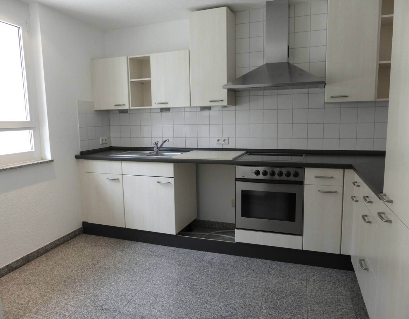 Moderne, helle Einbauküche mit Granitbodenbelag