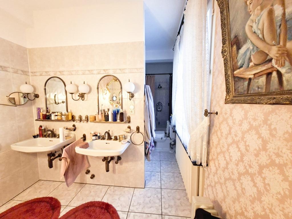 Badezimmer mit Doppelwaschbecken, WC, Dusche und Badewanne