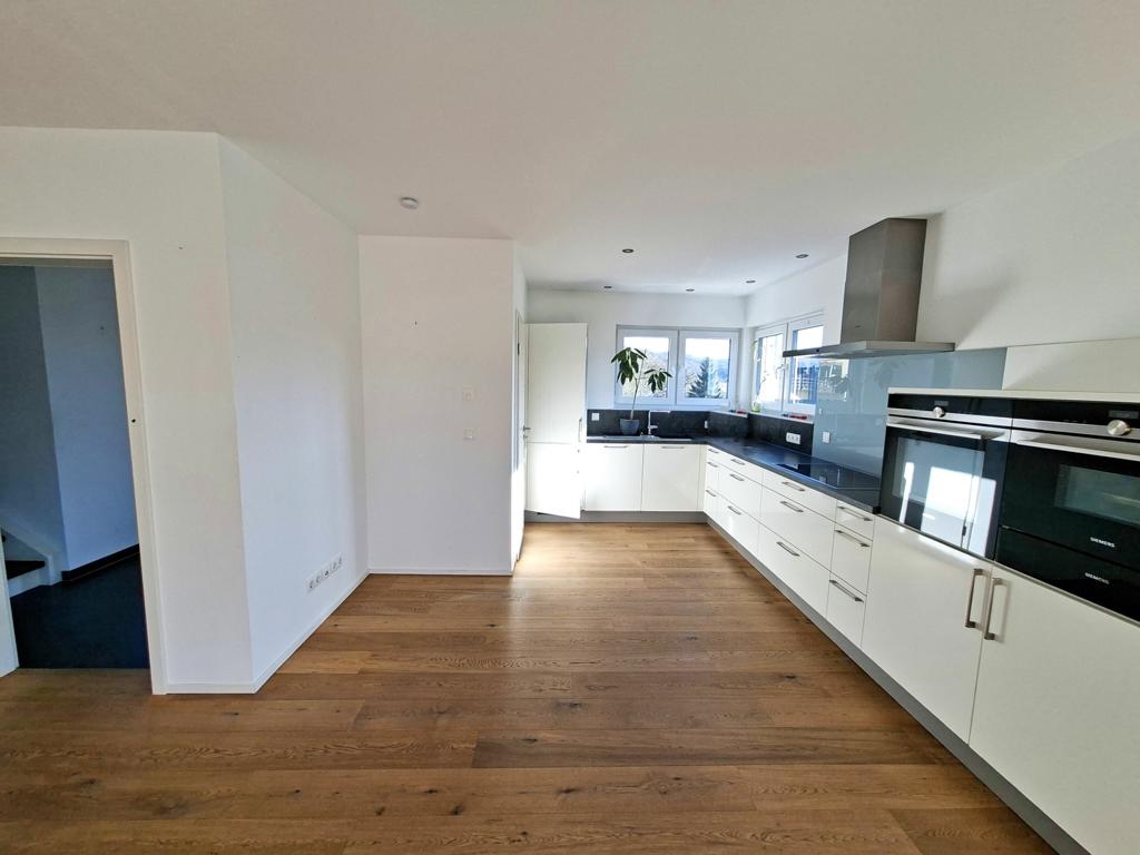 Offene, moderne Einbauküche mit separatem Abstellraum