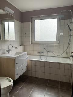 Badezimmer mit Fenster und Wanne