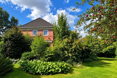 Gepflegter Garten mit liebevoll angelegten Beeten und altem Baumbestand