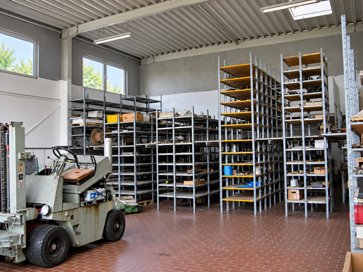 Helle Lagerhalle mit Gabelstapler und Regalen