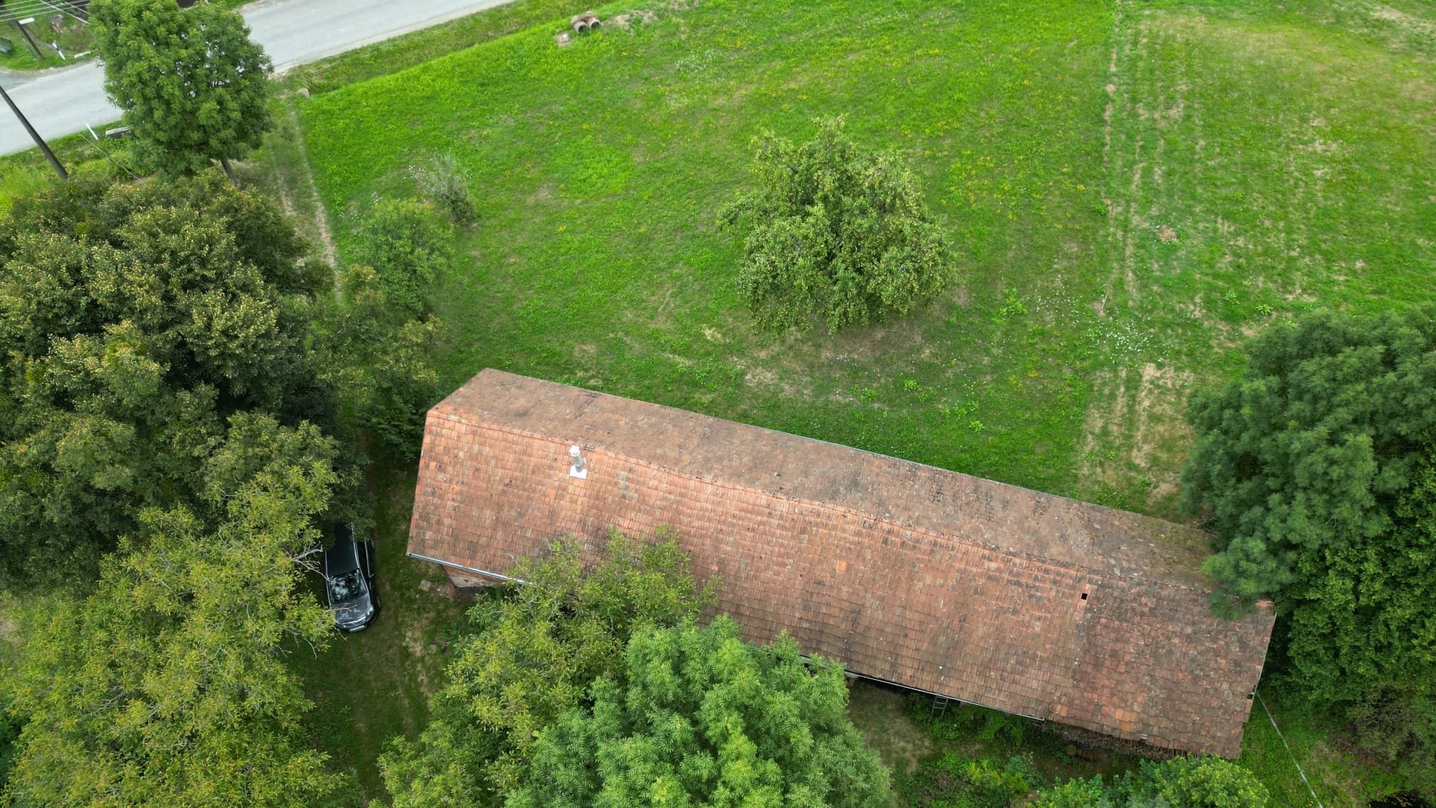 Blick au fdie Zufahrt und das sanierungsbedürftige Gebäude