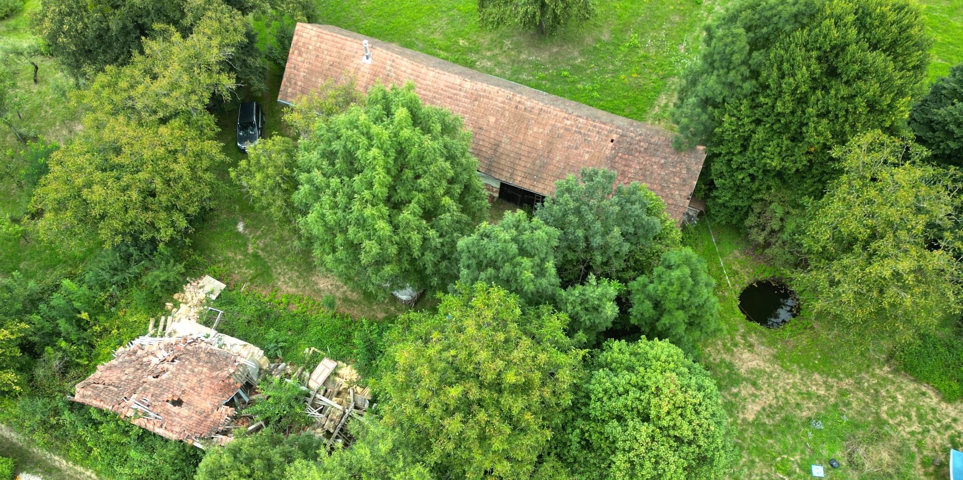 Blick auf eingestürztes Gebäude und sanierungsbedürftiges Gebäude