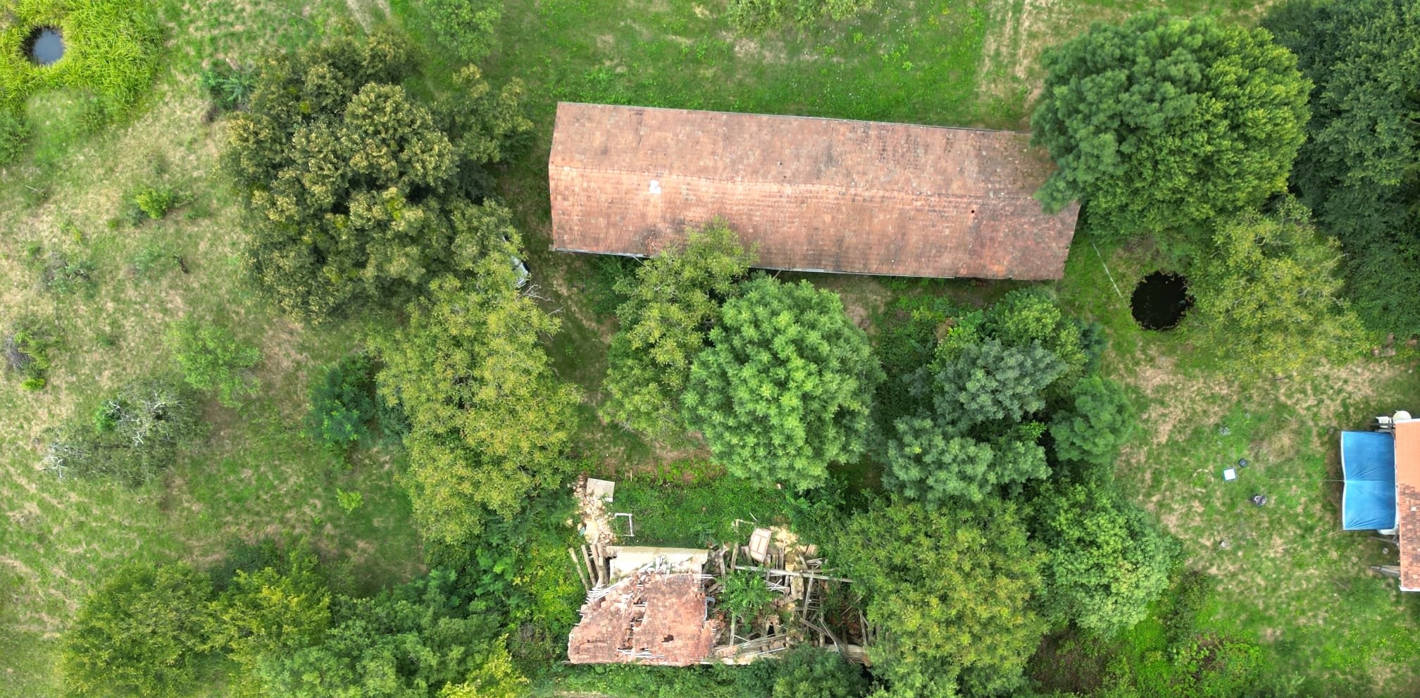 Blick auf zwei Regenawasserstellen - Beide Gebäude und Das Vordach vor dem Wohnwagen