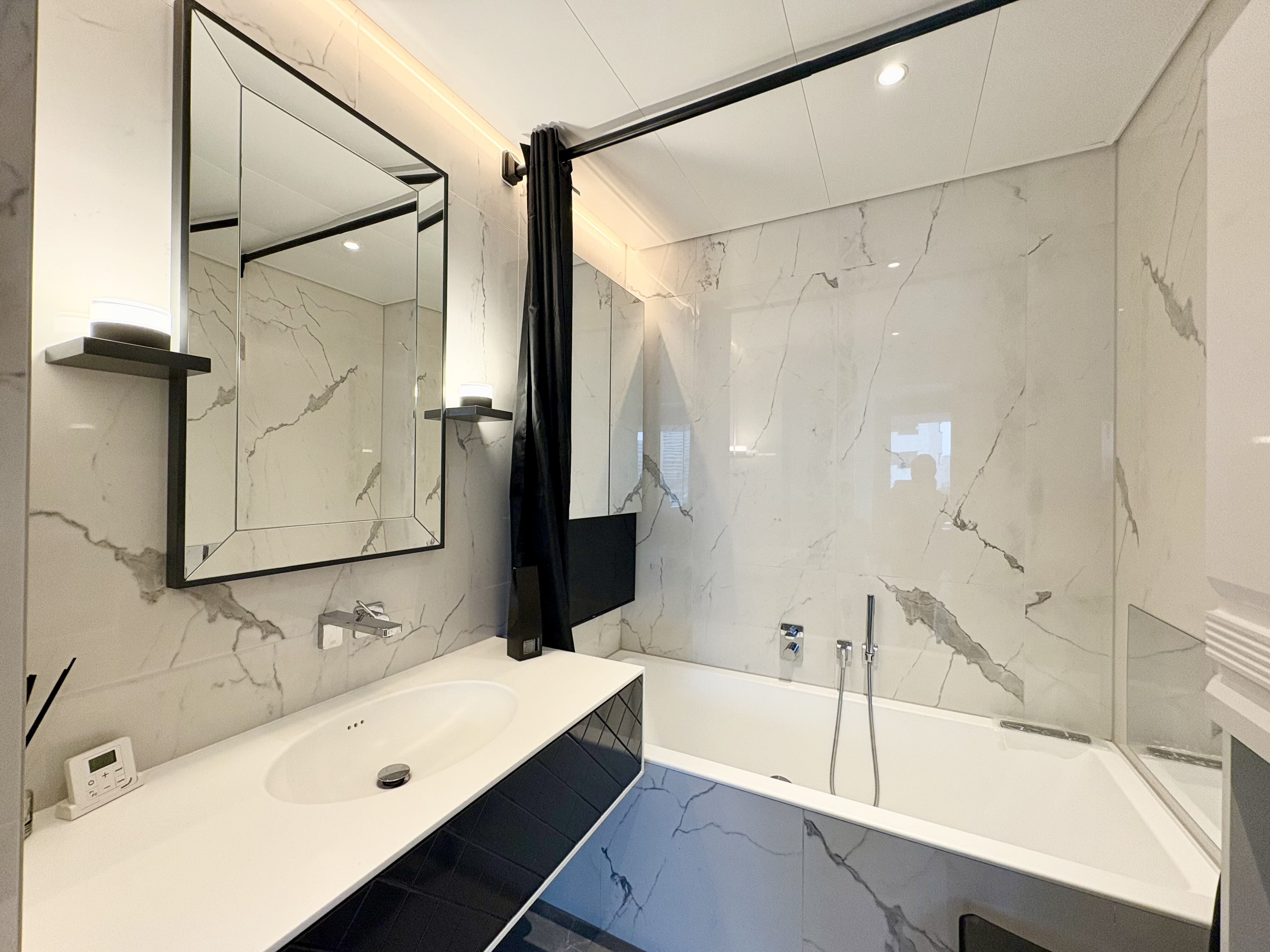 Badezimmer mit Badewanne und TV