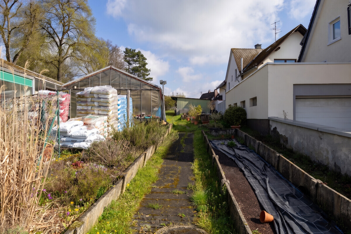 Lange Außenfront der Gewächshäuser mit angrenzendem Grünstreifen auf dem Gärtnerei-Grundstück in Siegen-Geisweid