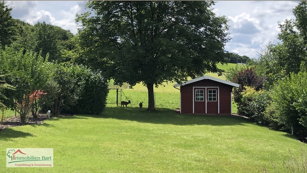 Garten mit zwei Gästen im Hintergrund