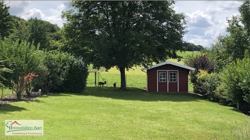 Garten mit zwei Gästen im Hintergrund