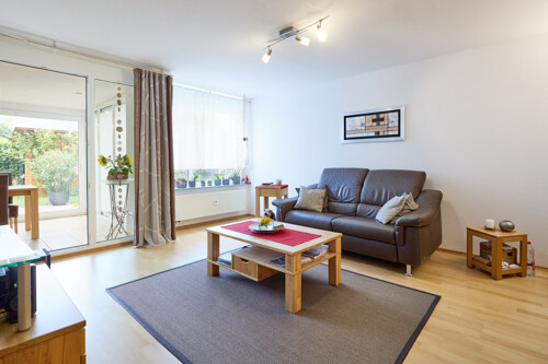 geräumiges Wohnzimmer mit Parkettboden und Zugang zum Wohnwintergarten sowie dem Gartenbereich