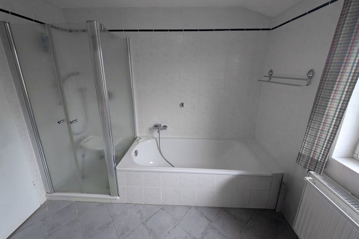 Badezimmer mit Badewanne und Dusche