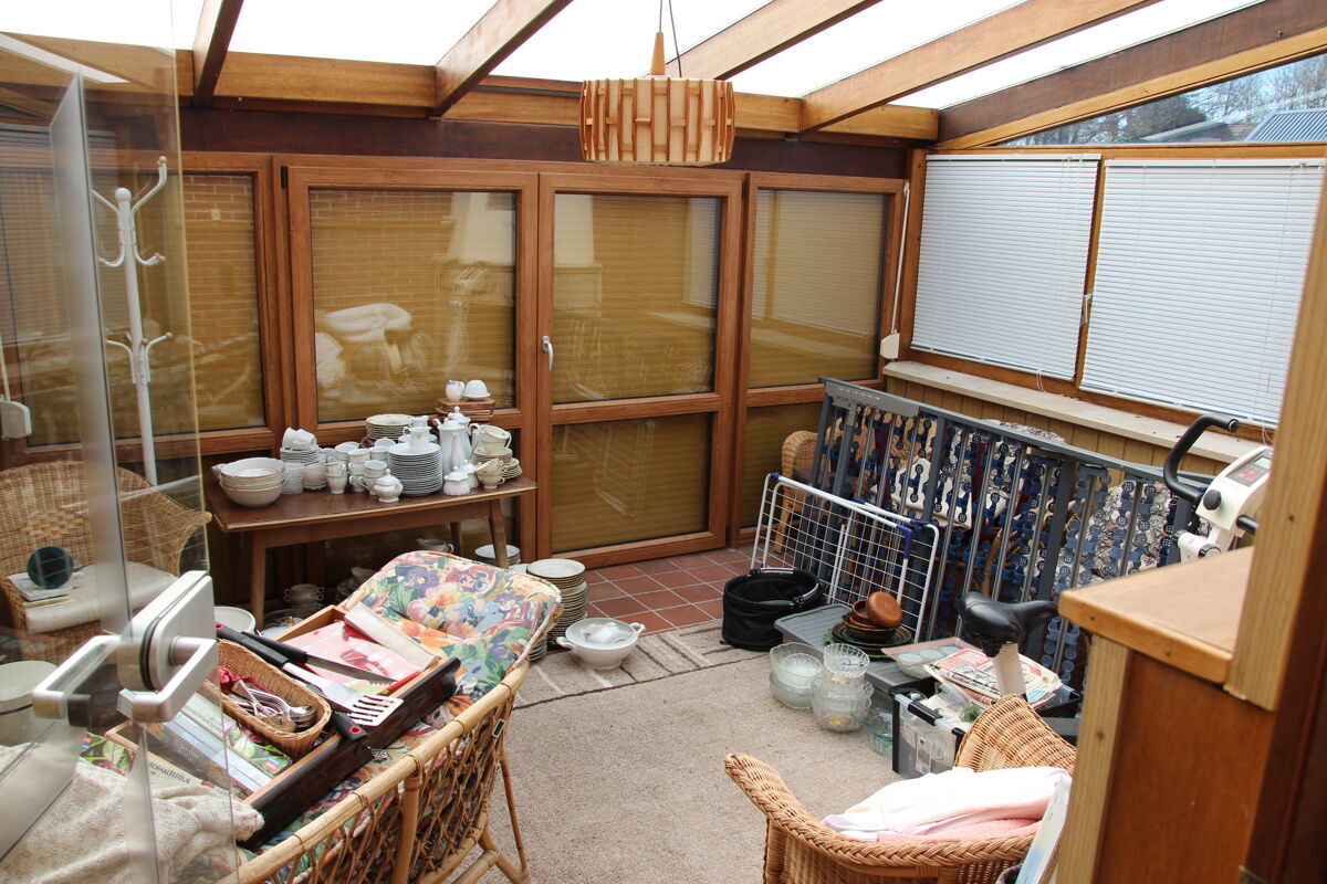 Lichtdurchfluteter Wintergarten mit Blick in den Garten