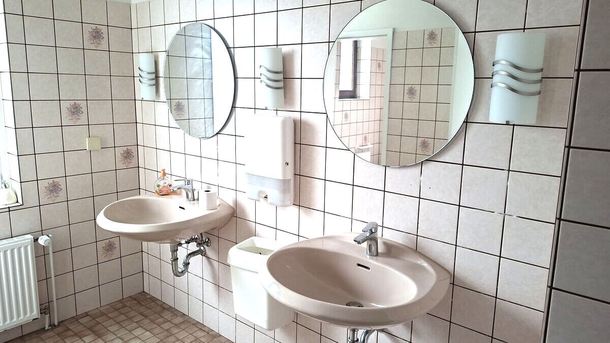 Gepflegter und gefliester Vorraum der sanitären Anlagen mit Doppelwaschbecken