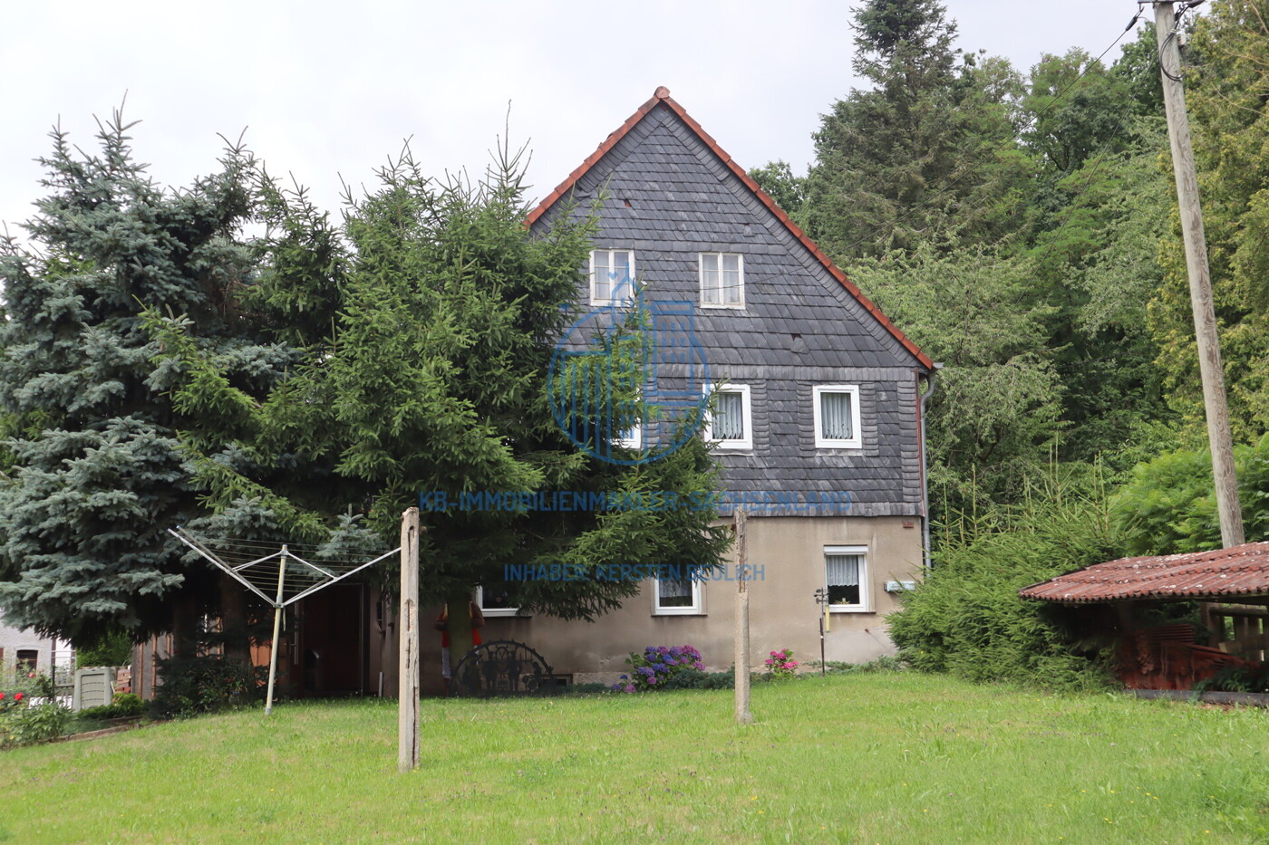 begrünte Freiflächen und Giebelansicht des EFH