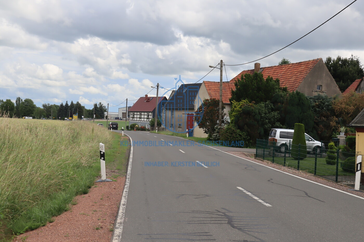 Erschließungsstraße sowie umliegende Bebauung und Nutzung