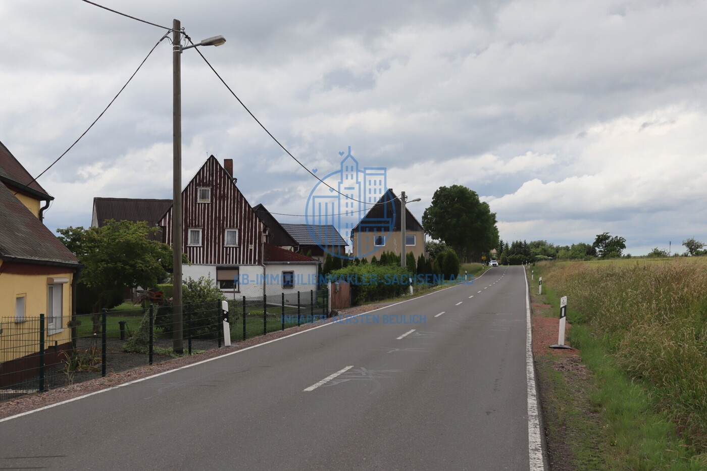 Erschließungsstraße sowie umliegende Bebauung und Nutzung