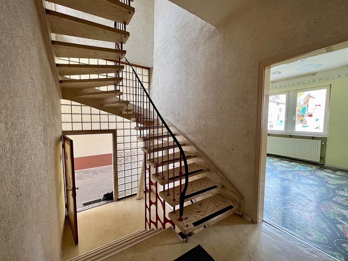 Geschwungene Steintreppe ins OG