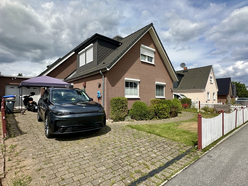 Einfahrt des Hauses mit Wallbox und Garage