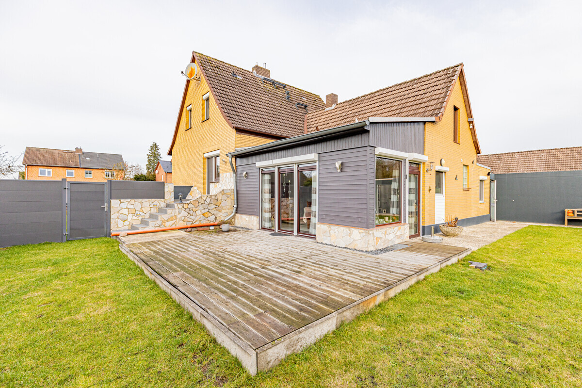 Hausrückseite mit Terrasse und Wintergarten