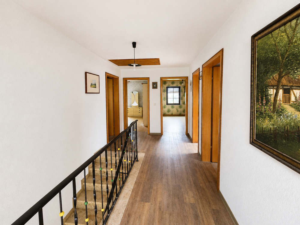 Treppenhaus im Obergeschoss mit Zugang in die Zimmer und Balkon