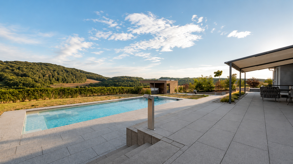Sonnige Poolterrasse mit beeindruckendem Panoramablick ins Grüne