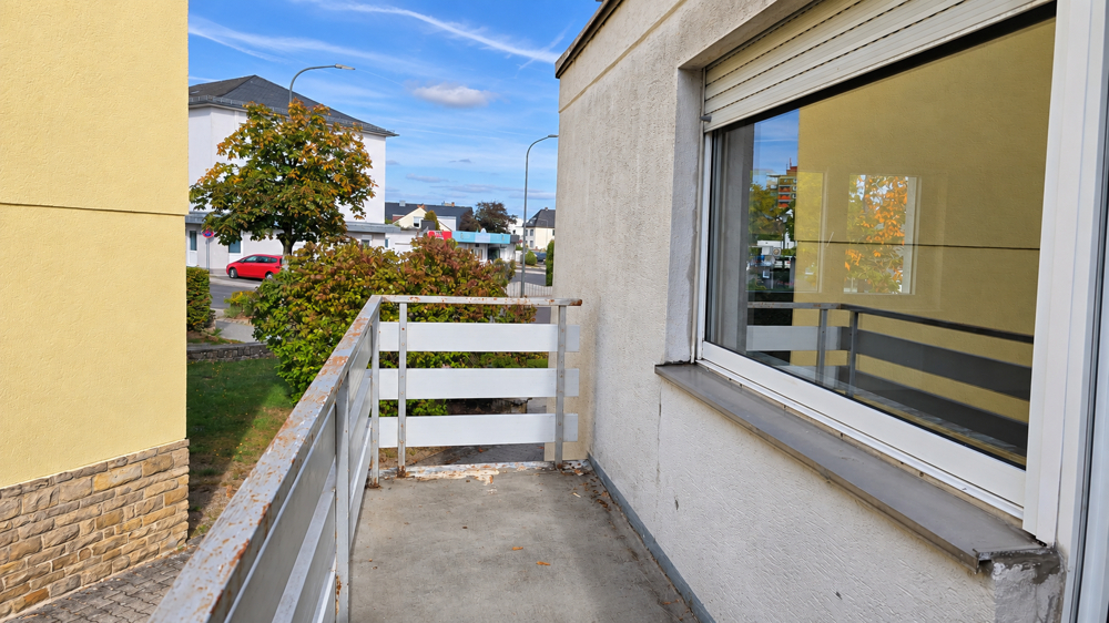 Balkon mit Platz für eine kleine Sitzecke und Blick in die Nachbarschaft