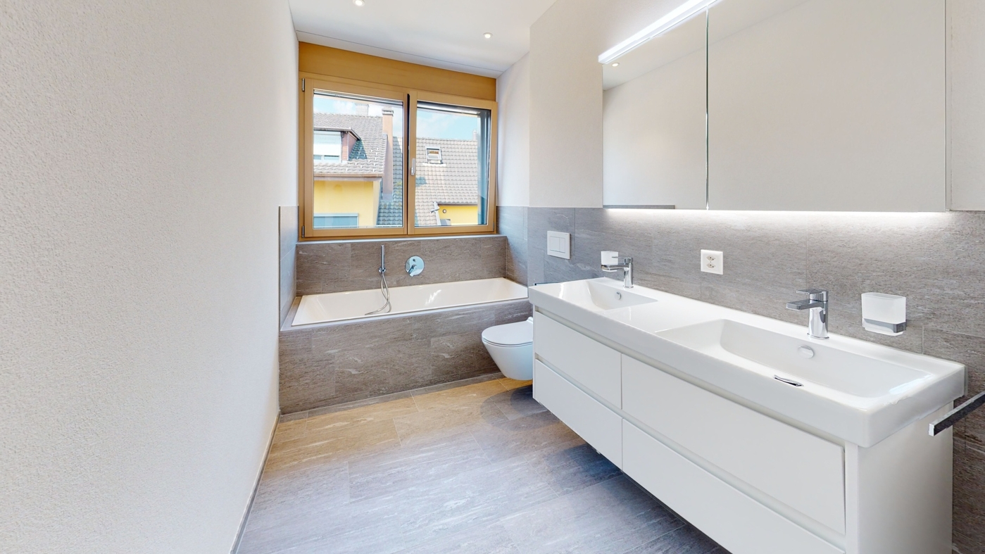 Badezimmer mit Badewanne, Doppelwaschtisch, WC und Dusche