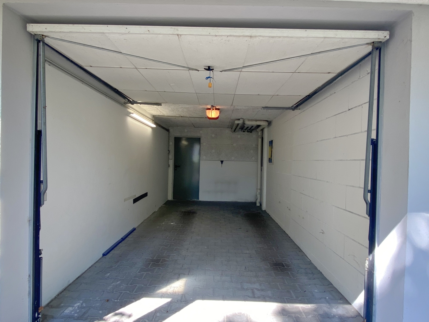 Garage mit elektrischem Garagentor und Zugang zum Haus