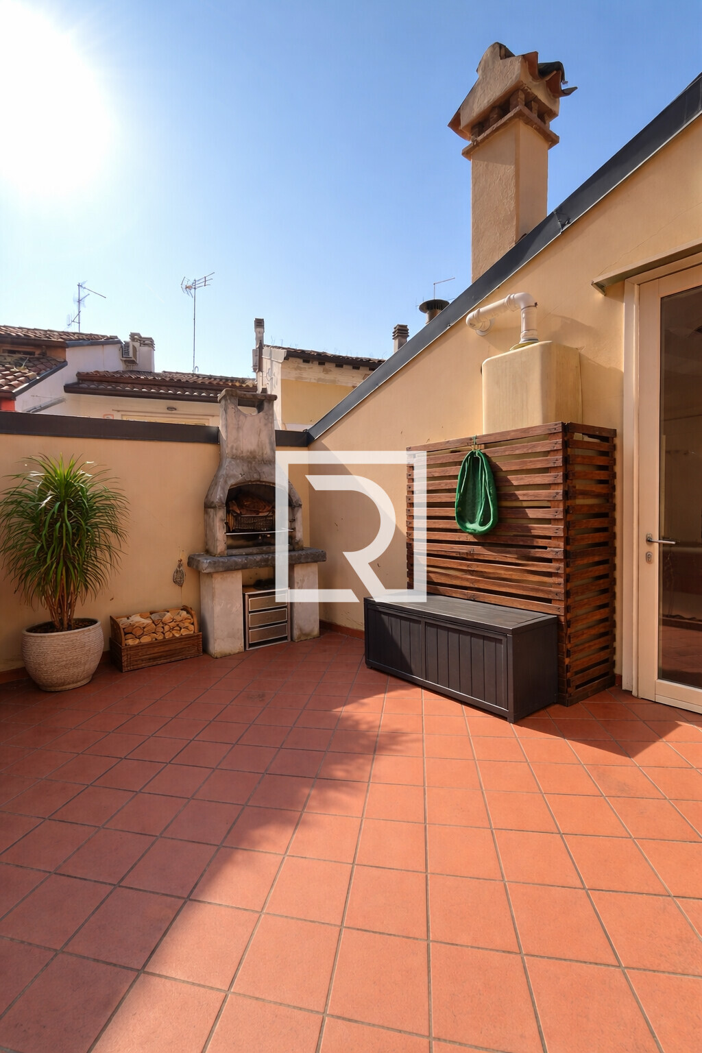 Terrazza soleggiata con barbecue e piante (1)