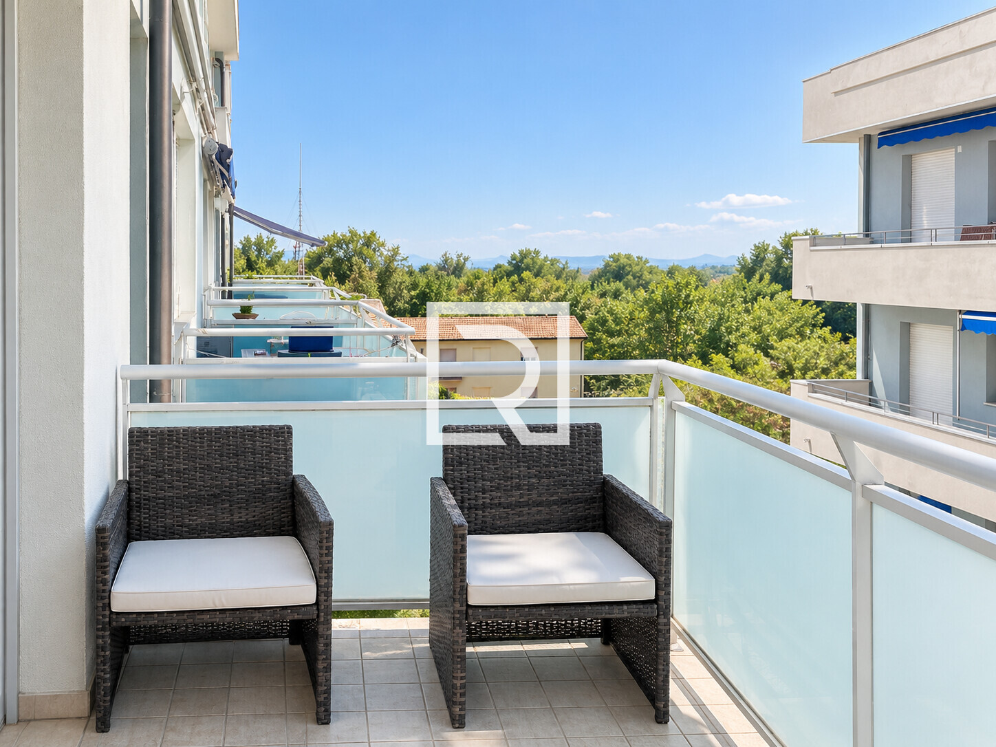 Balcone soleggiato con poltrone in rattan