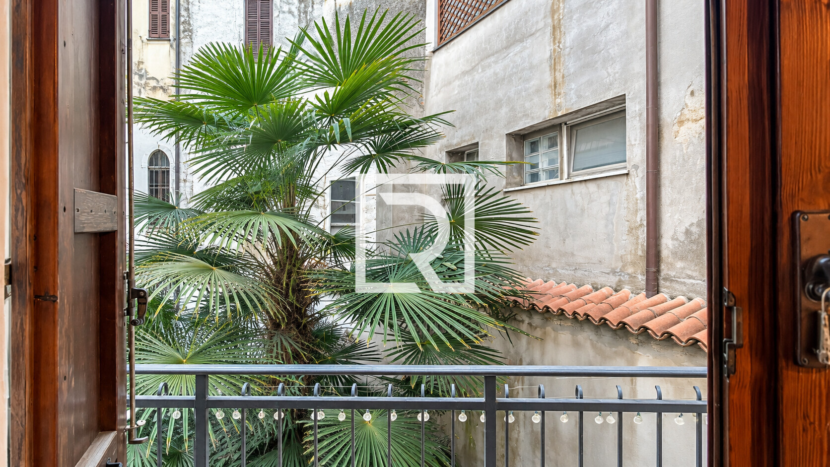 Mediterranean Courtyard Through Open Shutters