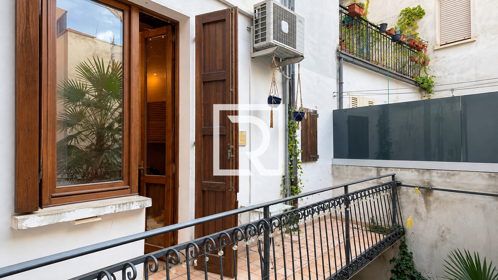 Sunlit Stucco Balcony with Hanging Plants