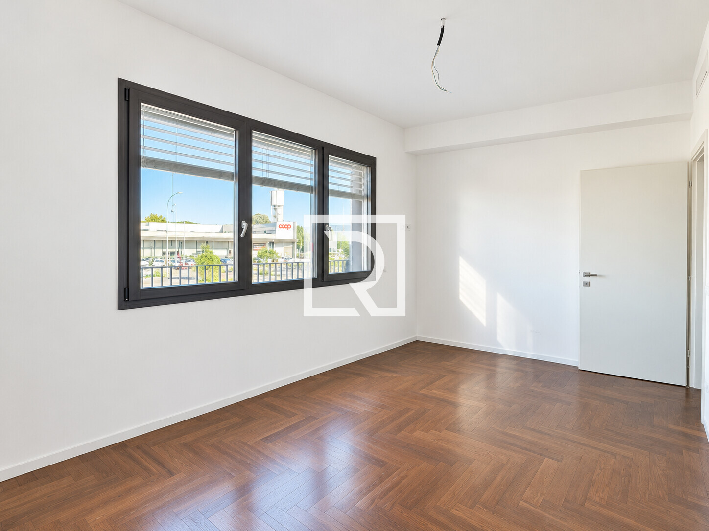 Interno moderno vuoto con parquet e luce naturale