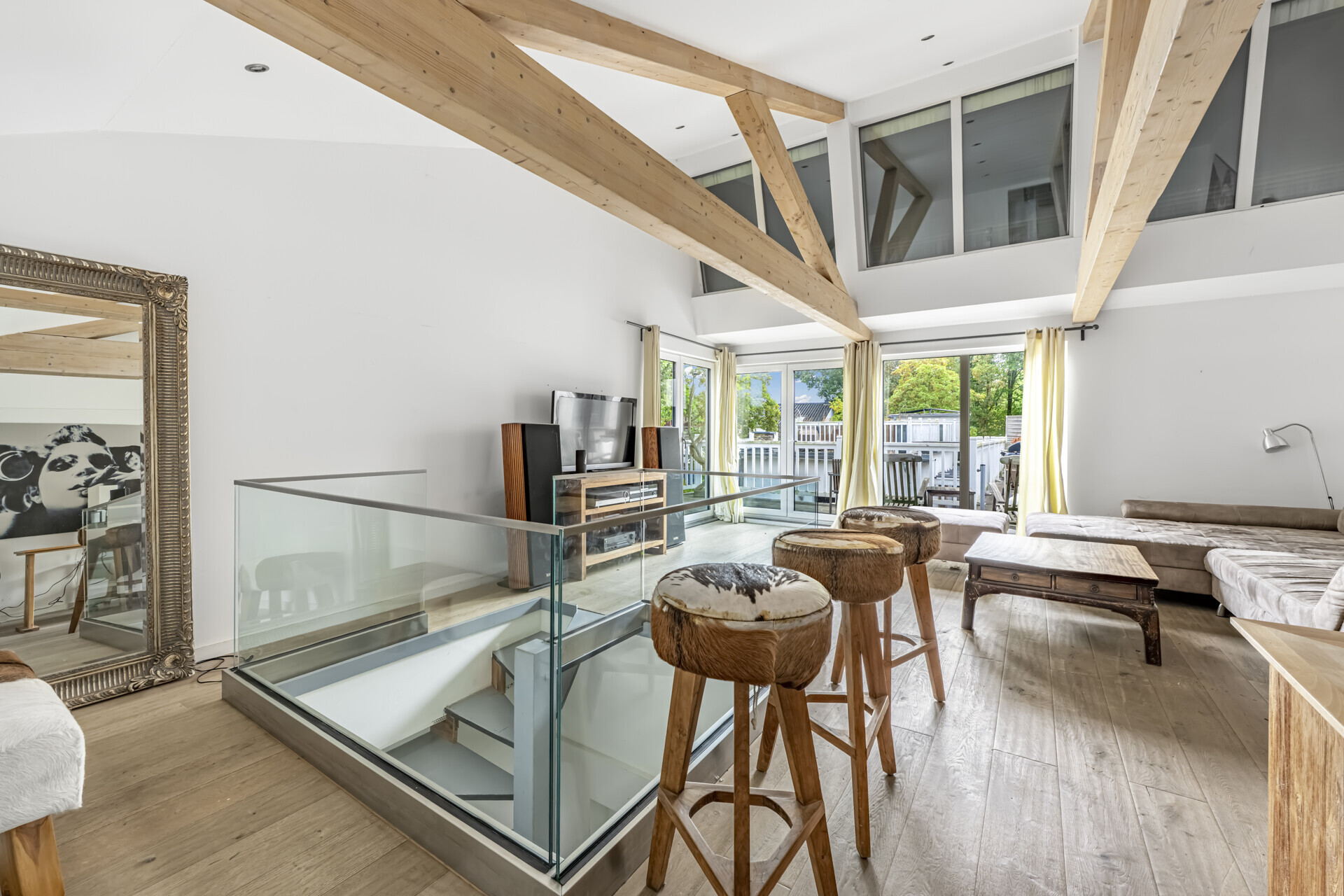 Wohnbereich mit sichtbaren Holzbalken und Terrassenzugang