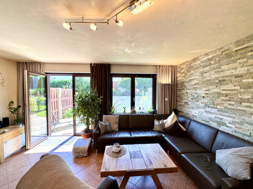 Geräumiges Wohnzimmer mit Natursteinverkleidung