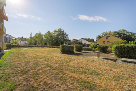 Grünfläche mit Aufenthaltsbereichen und Spielplatz