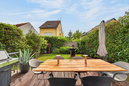 Blick von der Küche auf die sonnige Südterrasse und den angrenzenden Garten